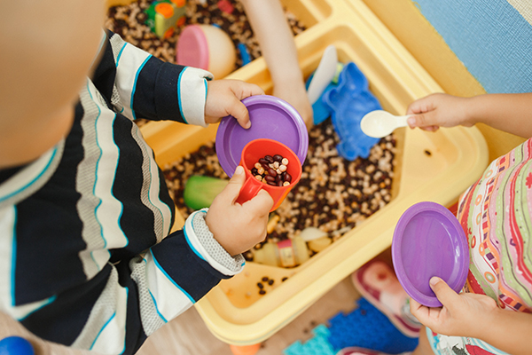 Kids playing with dishes and beans