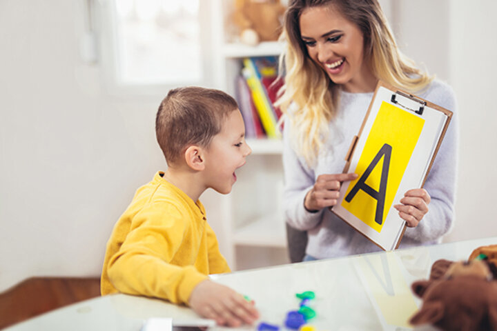 Woman holding clipboard up to child